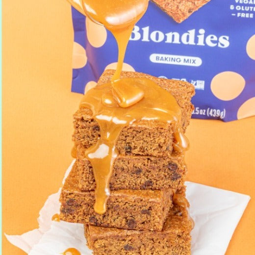Pumpkin Spice Caramel Blondies Image- Caramel poured over vegan blondies with Partake Blondies packaging in the background