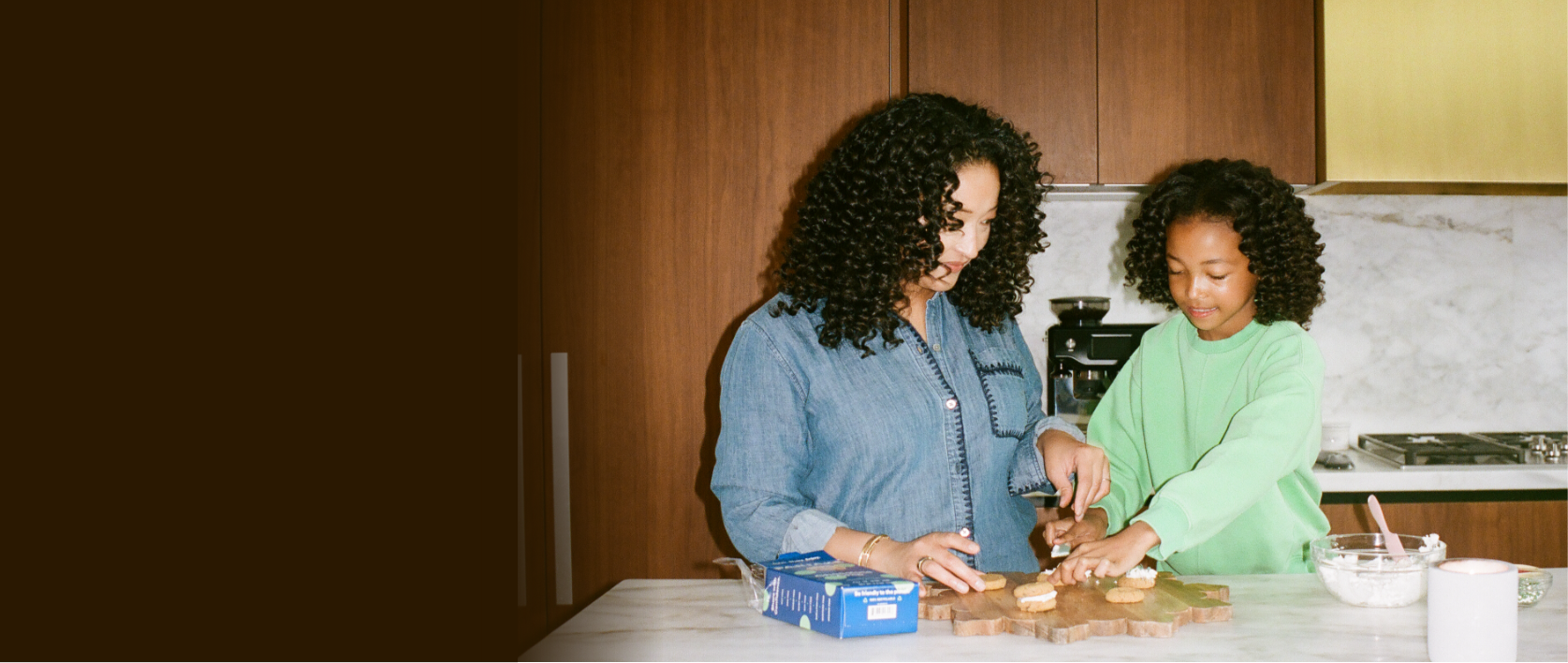 partake founder and her daughter in a kitchen preparing cookies together.